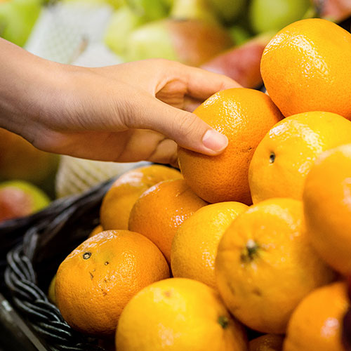 Hand picking up orange